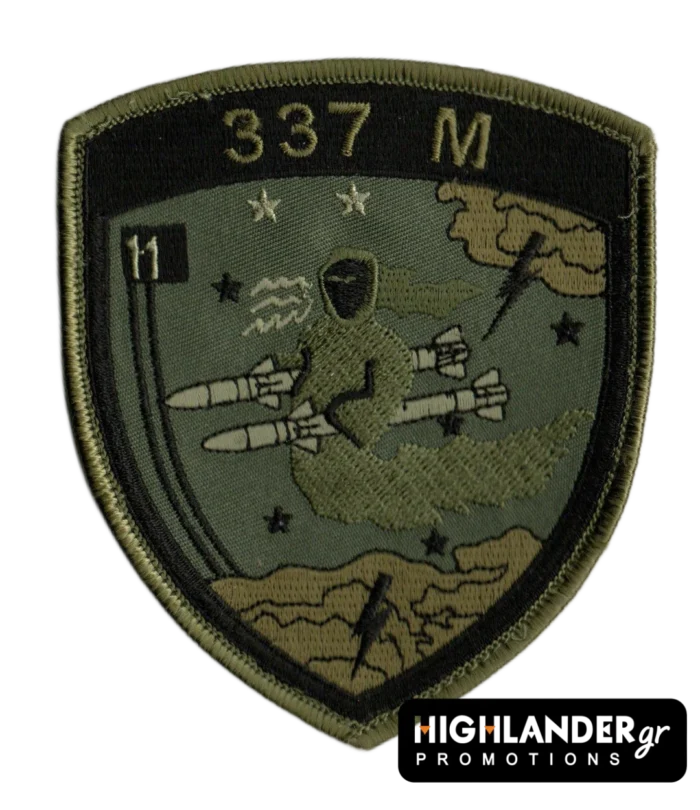 Low visibility embroidered patch with ghost riding two missiles, stars, clouds, lightning, "337 M" and "11" insignia, olive and sand colors.
