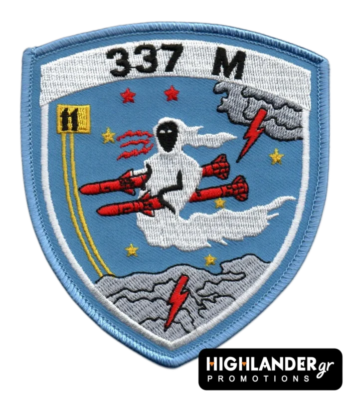 Cyan embroidered patch with ghost riding red missiles, stars, clouds, yellow squadron emblem, "337 M" text, and blue border.