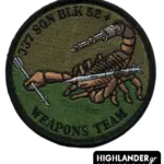 : Low visibility embroidered patch with scorpion holding missile and machine gun, olive/brown background, black border, and “337 SQN BLK 52+ WEAPONS TEAM” text.