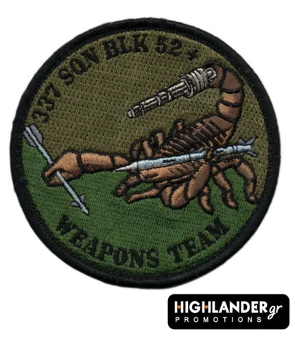 : Low visibility embroidered patch with scorpion holding missile and machine gun, olive/brown background, black border, and “337 SQN BLK 52+ WEAPONS TEAM” text.