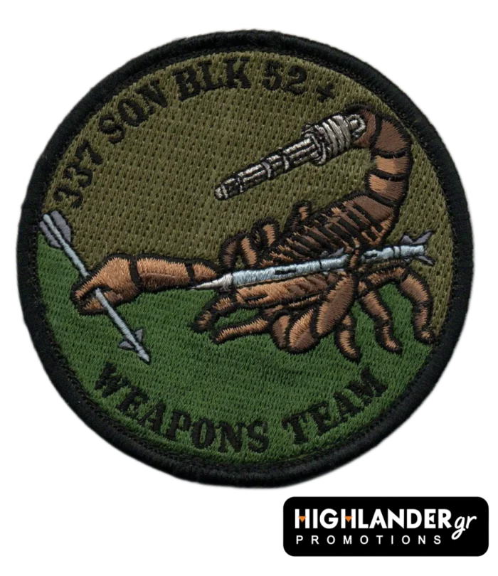 : Low visibility embroidered patch with scorpion holding missile and machine gun, olive/brown background, black border, and “337 SQN BLK 52+ WEAPONS TEAM” text.