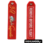 Red embroidered anniversary keychain for SA 342 Gazelle. Side A: "30 Years Gazelle" in gold with scorpion tail and helicopter image. Side B: "REMOVE BEFORE FLIGHT" text.