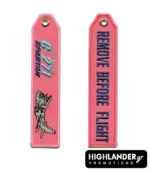 Pink embroidered aviation keychain for 354 MTM C-27J Spartan. Side A shows the aircraft and unit text. Side B shows "REMOVE BEFORE FLIGHT" in blue text.