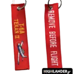 Red "Remove Before Flight" keychain for T-6A Texan II. Side A shows the aircraft and golden text; Side B shows white warning text