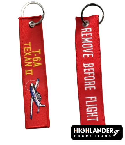 Red "Remove Before Flight" keychain for T-6A Texan II. Side A shows the aircraft and golden text; Side B shows white warning text