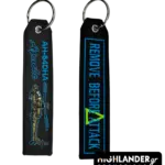 Black embroidered keychain showing AH-64DHA Apache helicopter on one side and Remove Before Attack text in blue on the other side.