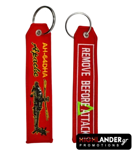 Red embroidered keychain showing AH-64DHA Apache helicopter on one side and Remove Before Attack text in white on the other side.