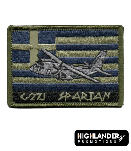 Ορθογώνιο κεντητό σήμα με το αεροσκάφος C-27J Spartan πάνω σε φόντο ελληνικής σημαίας με χρυσές και μπλε ρίγες. Κάτω αναγράφεται "C-27J SPARTAN" με αρχαιοελληνική