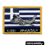 Rectangular tactical patch featuring a C-27J Spartan aircraft embroidered over a Greek flag with white and blue stripes. Bottom text reads "C-27J SPARTAN" in ancient-style font.