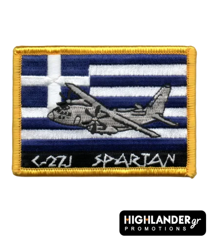 Rectangular tactical patch featuring a C-27J Spartan aircraft embroidered over a Greek flag with white and blue stripes. Bottom text reads "C-27J SPARTAN" in ancient-style font.