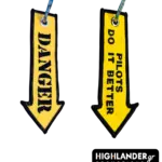 Yellow arrow-shaped embroidered keychain displaying DANGER text on one side and PILOTS DO IT BETTER on the other side.