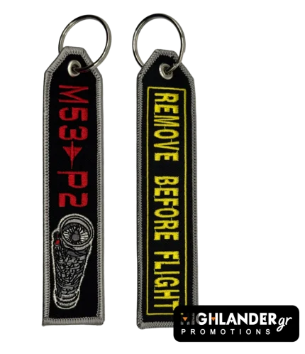 Black rectangular keychain featuring a detailed M53-P2 engine graphic and red text on one side, and yellow REMOVE BEFORE FLIGHT text on the other.