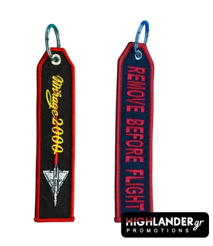Rectangular embroidered keychain featuring Mirage 2000 script and aircraft on a black background on one side, and REMOVE BEFORE FLIGHT