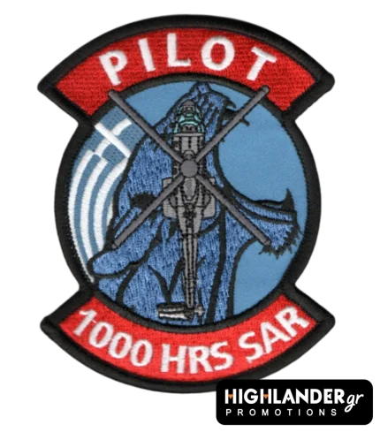 Embroidered aviation patch with red top and bottom tabs. Top reads "PILOT", bottom reads "1000 HRS SAR". Center shows a Super Puma helicopter on a blue background.
