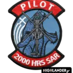 Embroidered aviation patch with red tabs. Top tab says "PILOT", bottom tab says "2000 HRS SAR". Center shows a Super Puma helicopter on a blue background.