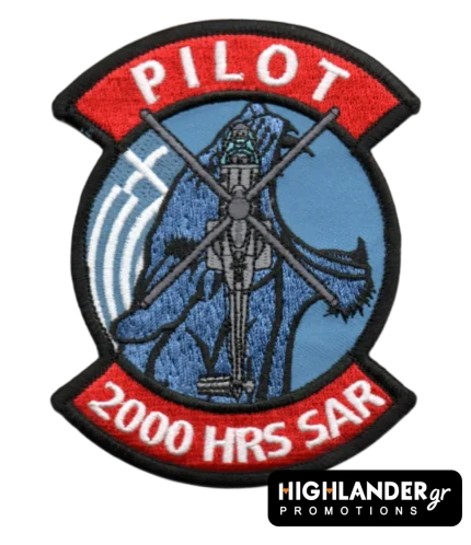 Embroidered aviation patch with red tabs. Top tab says "PILOT", bottom tab says "2000 HRS SAR". Center shows a Super Puma helicopter on a blue background.