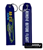 Blue embroidered keychain for AB-212 ASW helicopter. Side A shows the helicopter and text. Side B shows "REMOVE BEFORE FLIGHT" in white text.