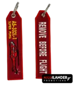 Red embroidered keychain for the AS-332L-1 Super Puma. Side A shows a red helicopter silhouette and yellow model text; Side B shows white "Remove Before Flight" text.