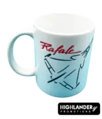 A white ceramic mug featuring a minimalist black line-art drawing of a Rafale fighter jet and the word 'Rafale' written in red cursive.