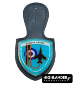A navy blue leather badge holder featuring the 117 Combat Wing enamel crest with the Greek motto "Exthrous Amynou", a black fighter jet silhouette, and the HAF roundel.