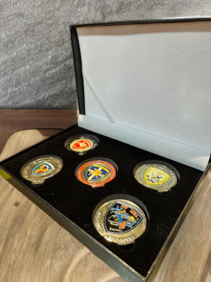 Black velvet-lined presentation box containing five gold-tone military challenge coins from various Hellenic Air Force and Army Aviation units.