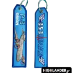 Dual-sided light blue embroidered keychain. Side A shows a P-3 Orion aircraft with the text "P-3 ORION". Side B shows "353 ΜΝΑΣ" with winged trident symbols.