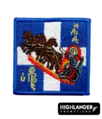 Square embroidered morale patch showing Prophet Elias in a chariot of fire drawn by four horses against a blue and white Greek flag.