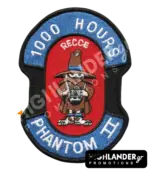 Shaped embroidered flight patch for 1000 hours in Recce Phantoms, featuring a blue Spook mascot with a camera, on a red and blue background.
