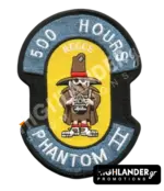 Shaped embroidered flight patch for 500 hours in Recce Phantoms, featuring a brown Spook mascot with a camera, on a yellow and blue background.
